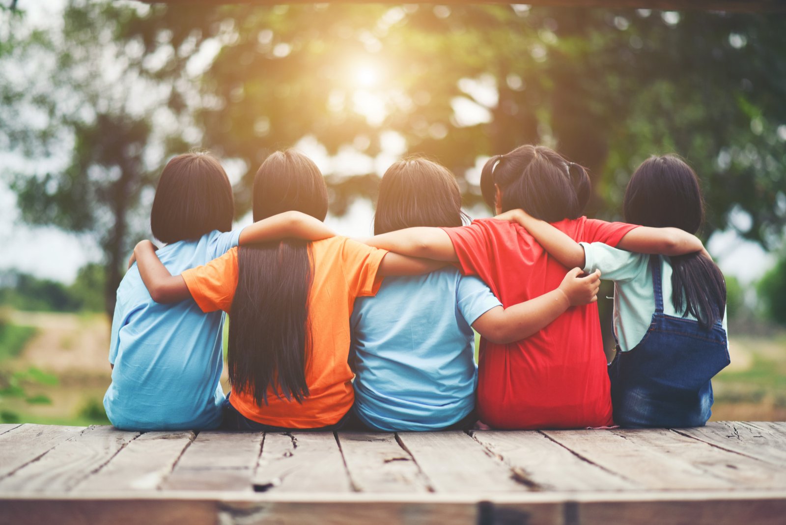 group-kids-friends-arm-around-sitting-together